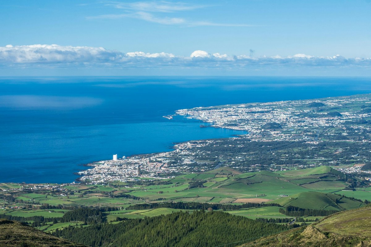 Green volcanic hills meeting the Atlantic on São Miguel in the Azores