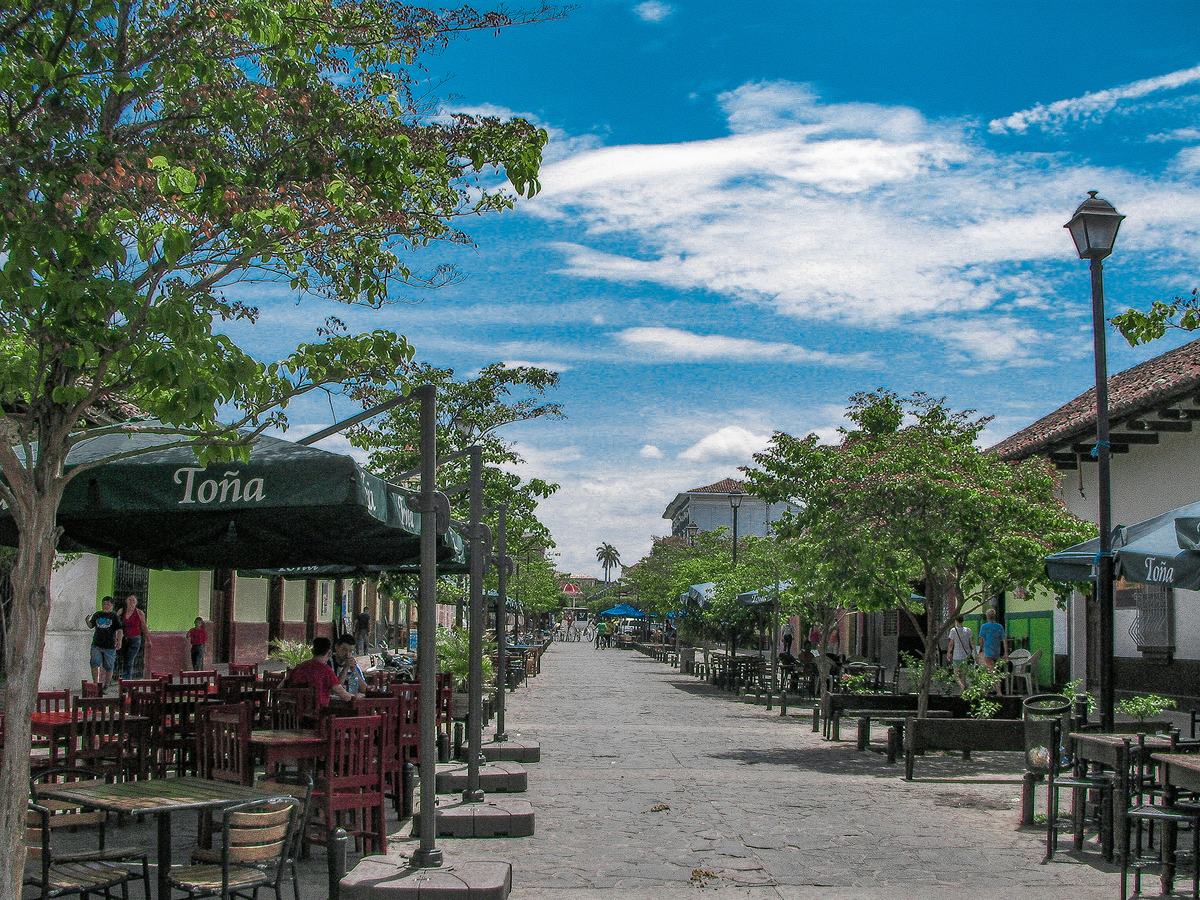 Calle La Calzada lined with colourful colonial buildings and outdoor seating in Granada, Nicaragua