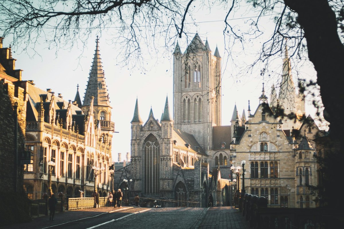 St Nicholas' Church and neighbouring historic buildings in Ghent, seen from a bridge at golden hour