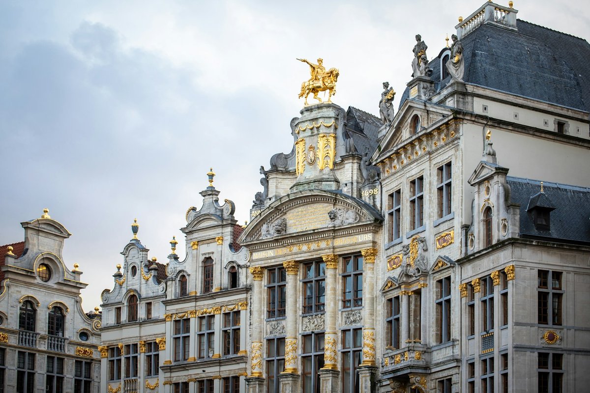 Gilded Baroque façades on Brussels Grand Place, with a gold equestrian statue on the roofline