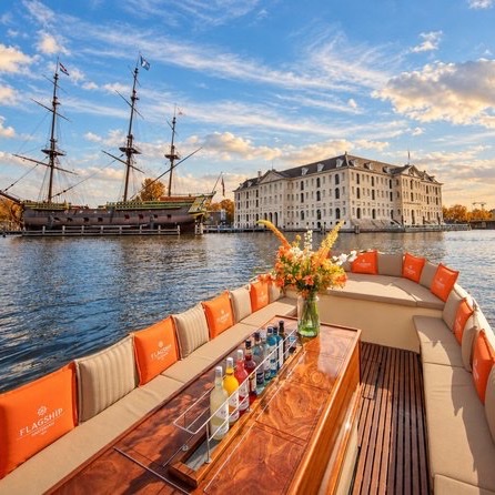 Luxury Amsterdam canal cruise boat with Flagship Amsterdam seating and drinks table facing the Maritime Museum