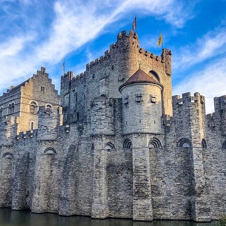 Gravensteen Castle stone walls and turrets rising above the moat in Ghent