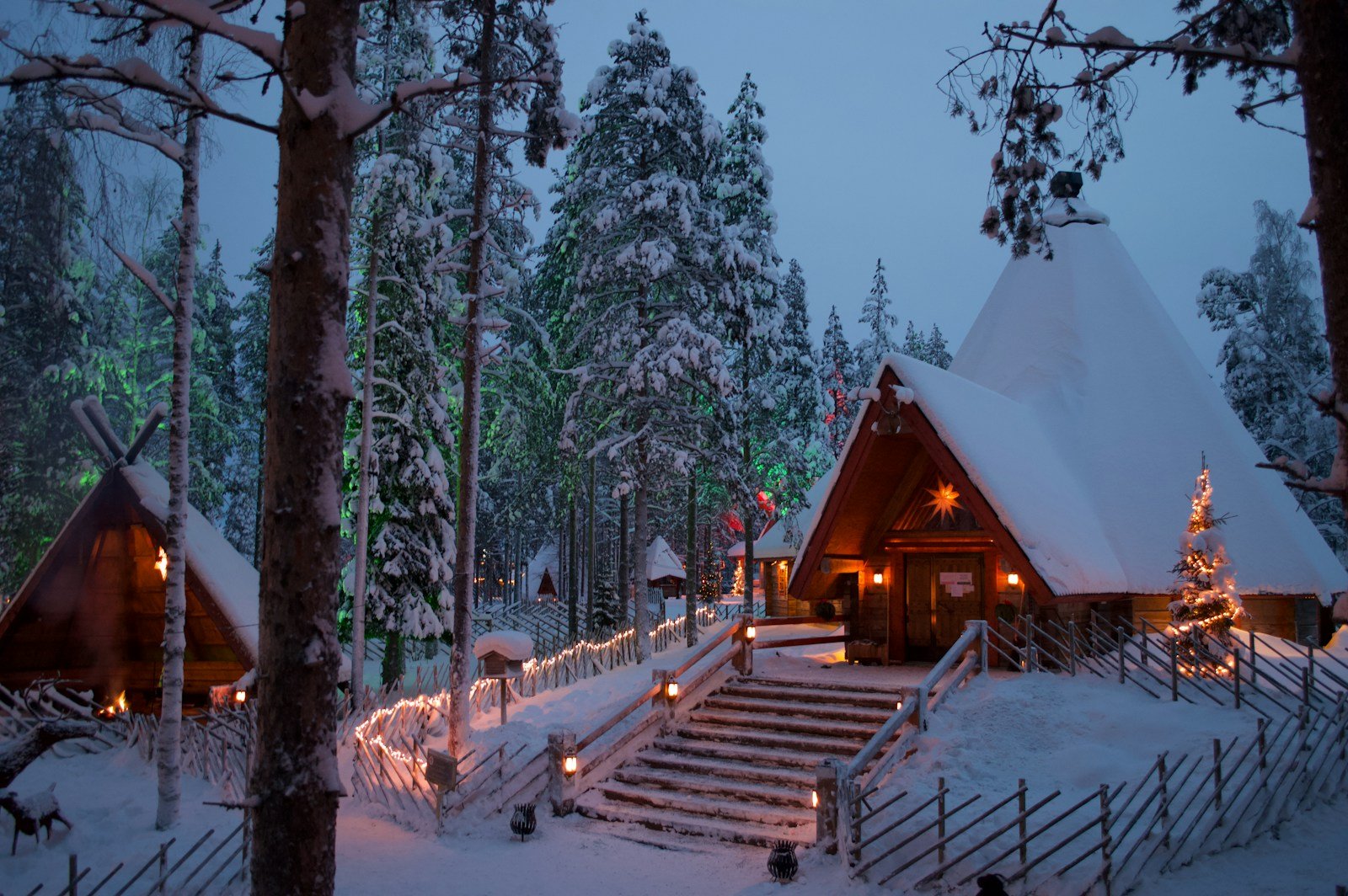 Cosy snow-covered cabin lit with Christmas lights in Rovaniemi, Finland