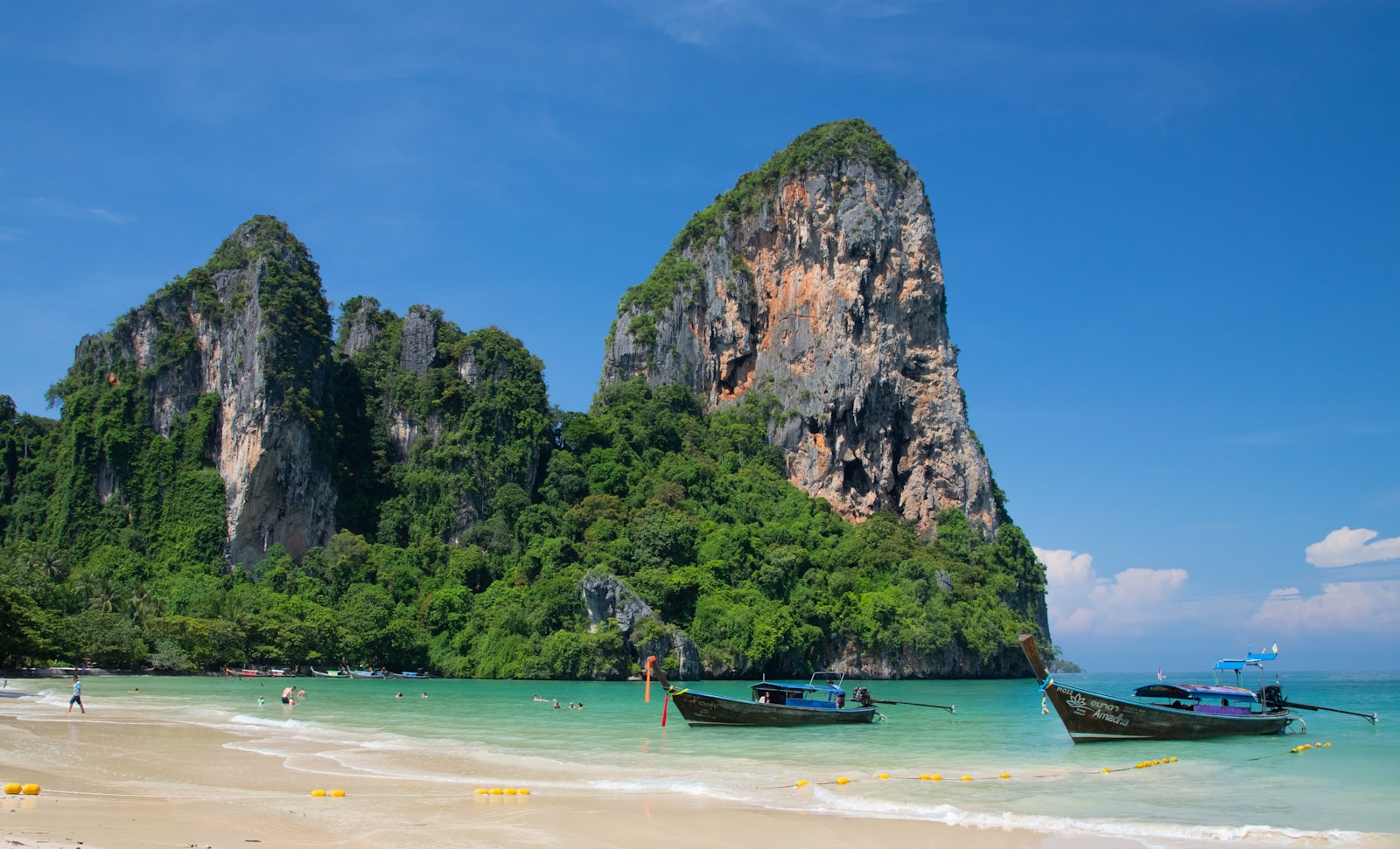Railay Beach with long-tail boats and limestone cliffs
