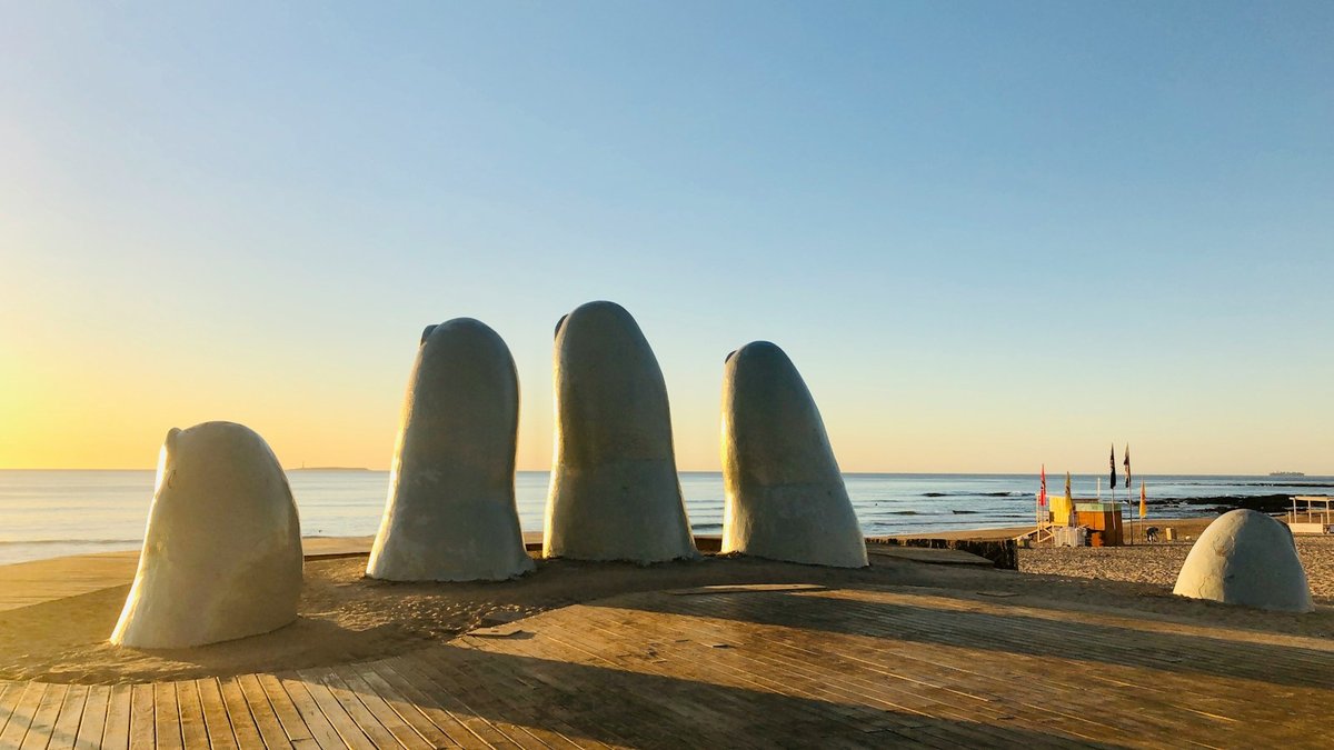The white finger sculptures of La Mano rising from a wooden deck above the beach at Punta del Este
